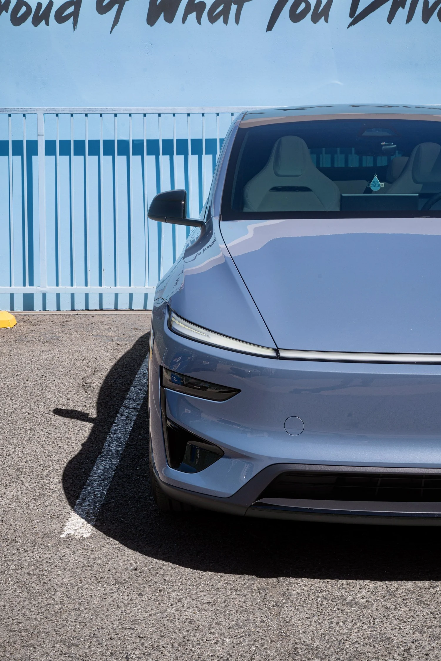 Close front view of the Model Y Performance showing the windshield, Glacier Blue hood and headlight