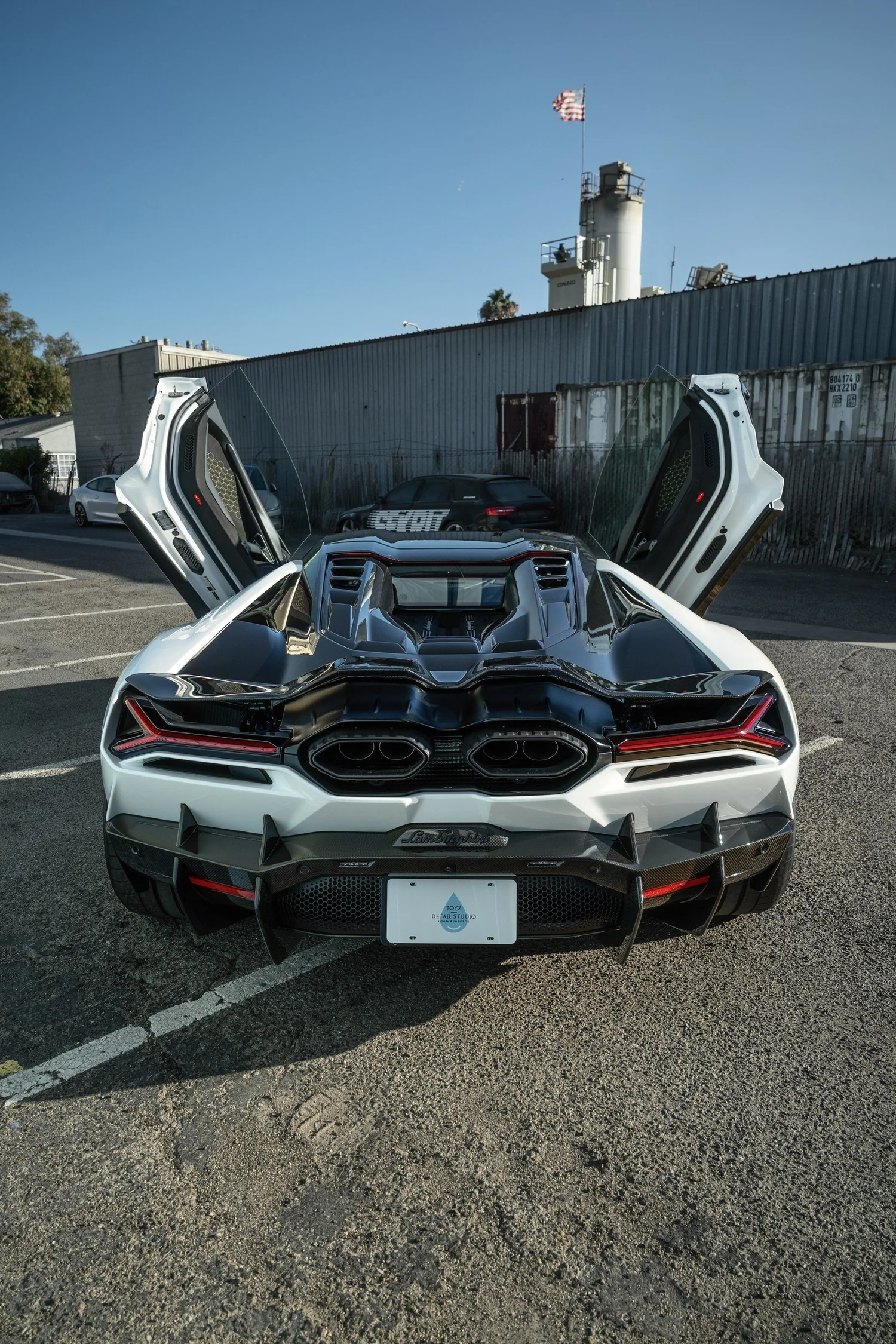 Rear of the white Revuelto with raised scissor doors, engine bay and rear aero visible.