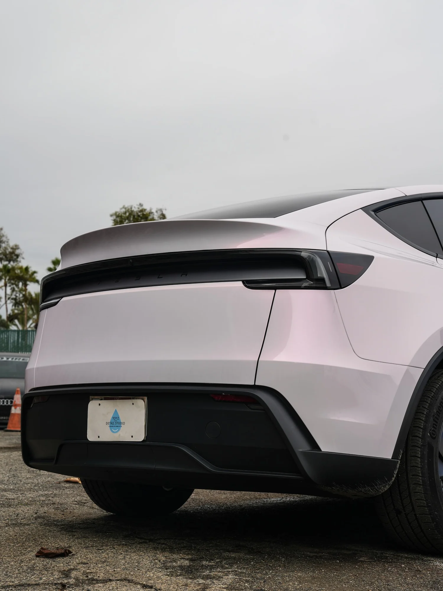 Pale Blush Pink Tesla Model Y after Vinyl Wrap, low-angle rear view