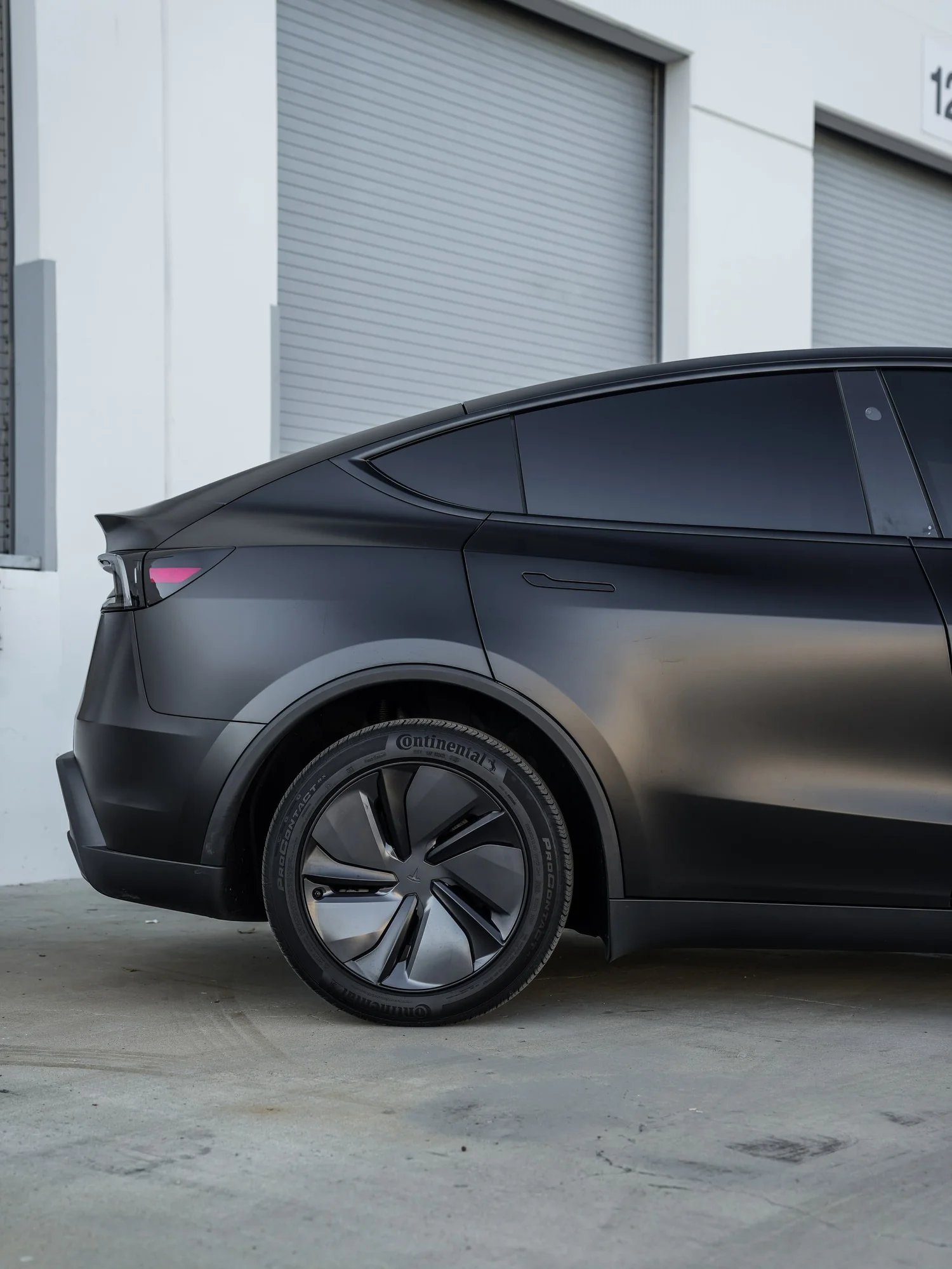 Tesla Model Y 3M Satin Black after Vinyl Wrap, rear-quarter and wheel view