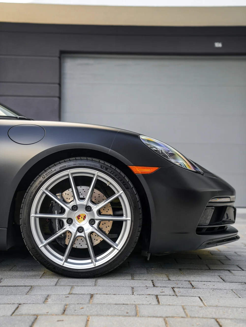 Porsche 718 Cayman GTS with 3M Satin Black vinyl wrap, front wheel and side body detail