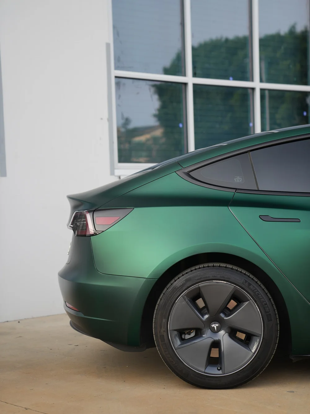 Tesla Model 3 rear wheel and quarter panel in Ghost Matte Green vinyl wrap