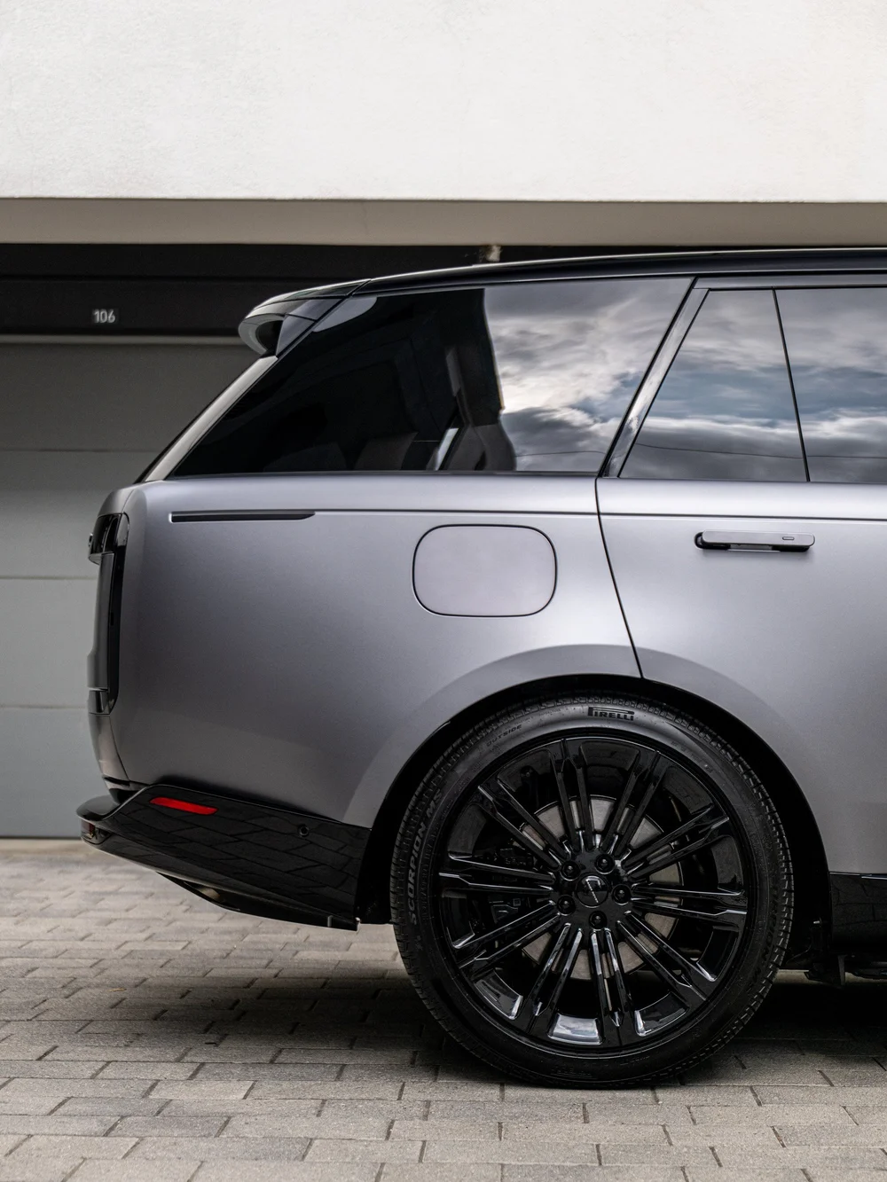 Range Rover rear quarter detail showing the satin rear fender, fuel door, black rear wheel and rear side window.