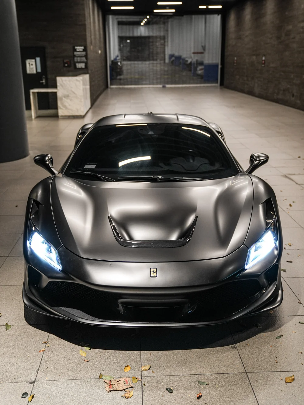 Straight front view with illuminated headlights — Ferrari F8 3M Satin Black vinyl wrap project