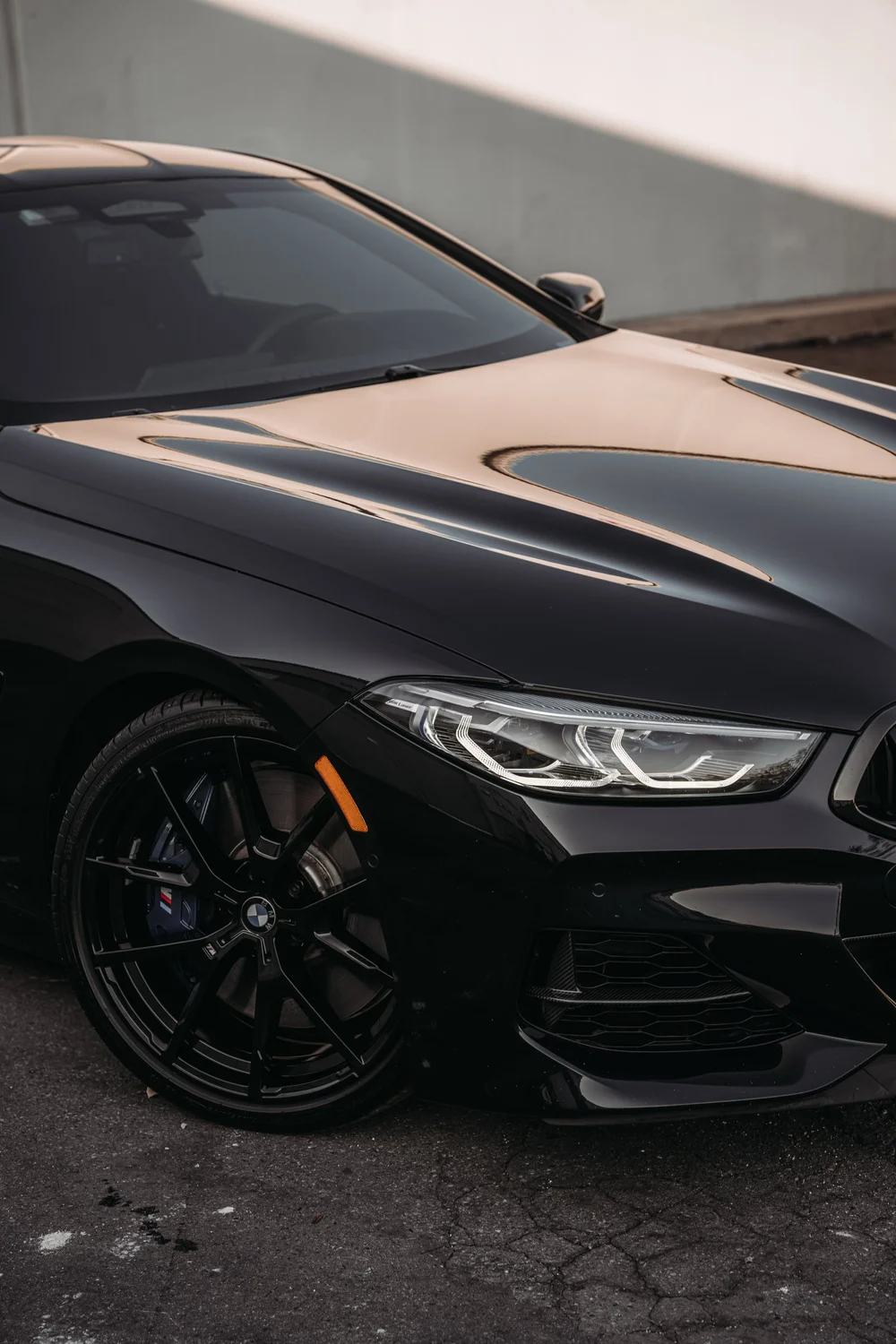 BMW M850i front-corner detail showing the headlight, fender and wheel area