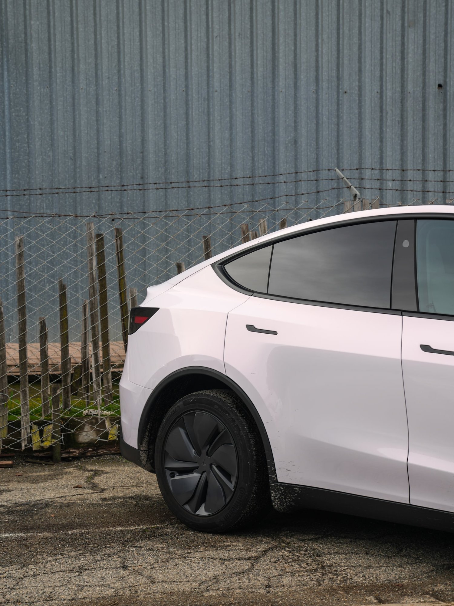 Pale Blush Pink Tesla Model Y after Vinyl Wrap, rear-quarter and wheel view