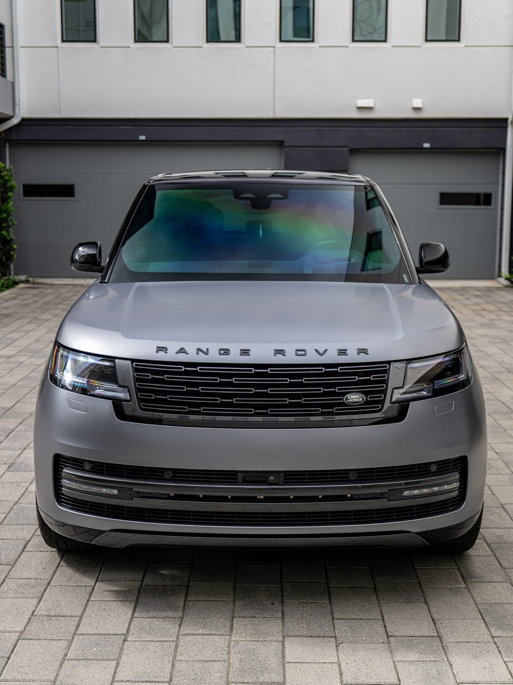 Straight-on front view of the Range Rover LWB P400 SE, including the grille, headlights and satin Eiger Grey hood.