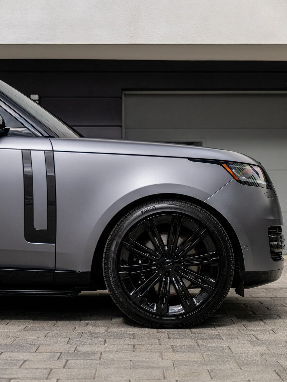 Black front wheel and satin Eiger Grey front fender on the Range Rover LWB, with the vertical gloss black side trim.