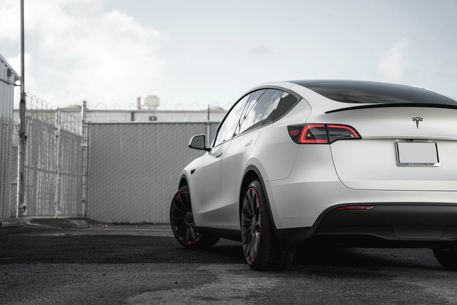 Satin Pearl White Tesla Model Y with Custom Exterior Accents after Vinyl Wrap, rear-quarter and wheel view