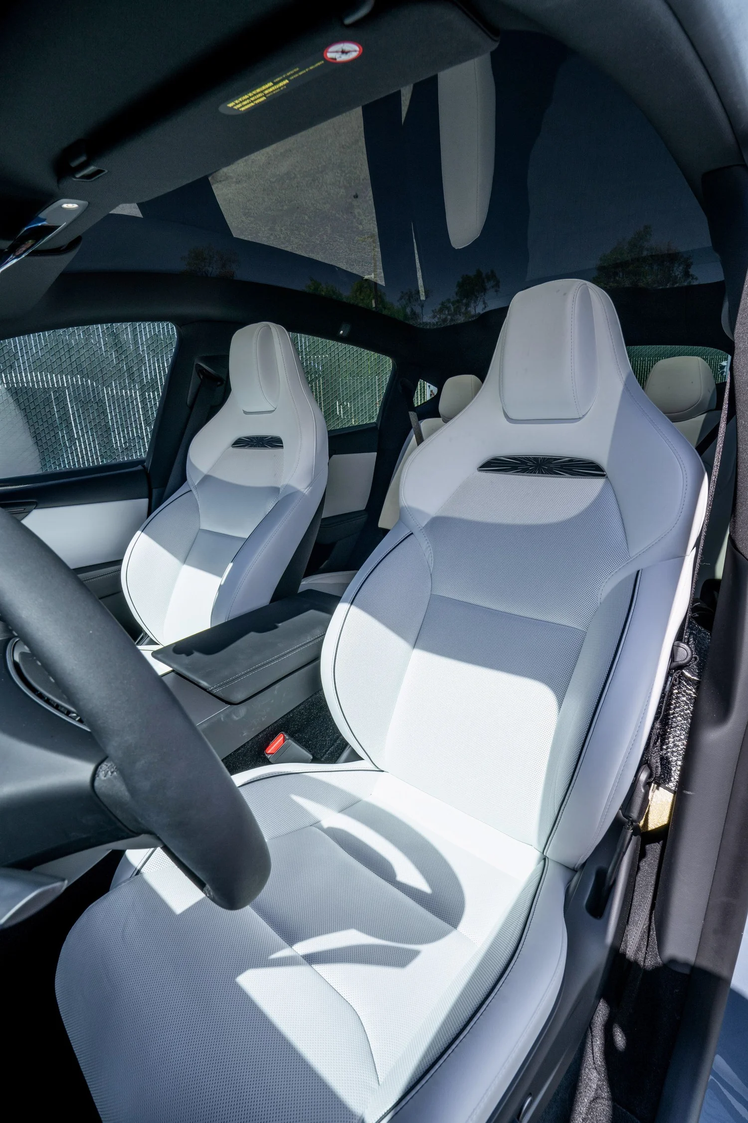 White front seats and cabin of the 2026 Tesla Model Y Performance viewed through the open front door
