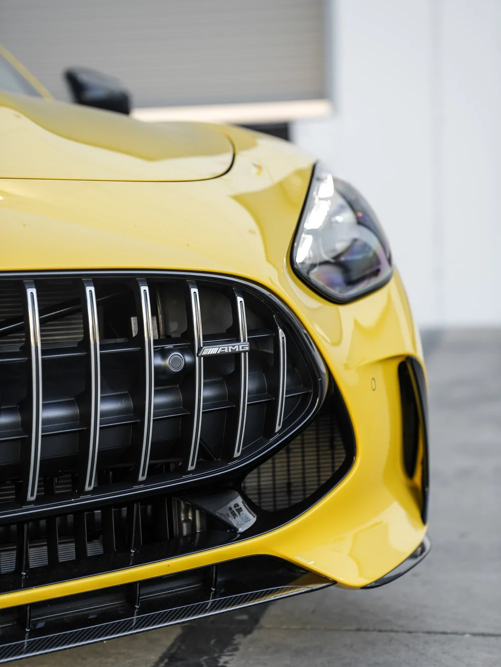 GT 63 vertical grille and headlight close-up beneath the yellow hood