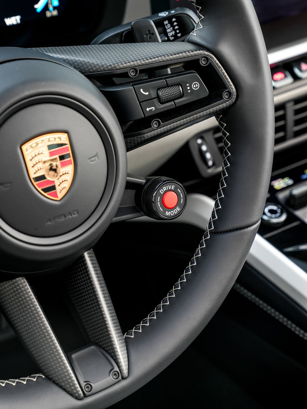 Porsche steering wheel crest, controls and red rotary knob with contrasting stitching