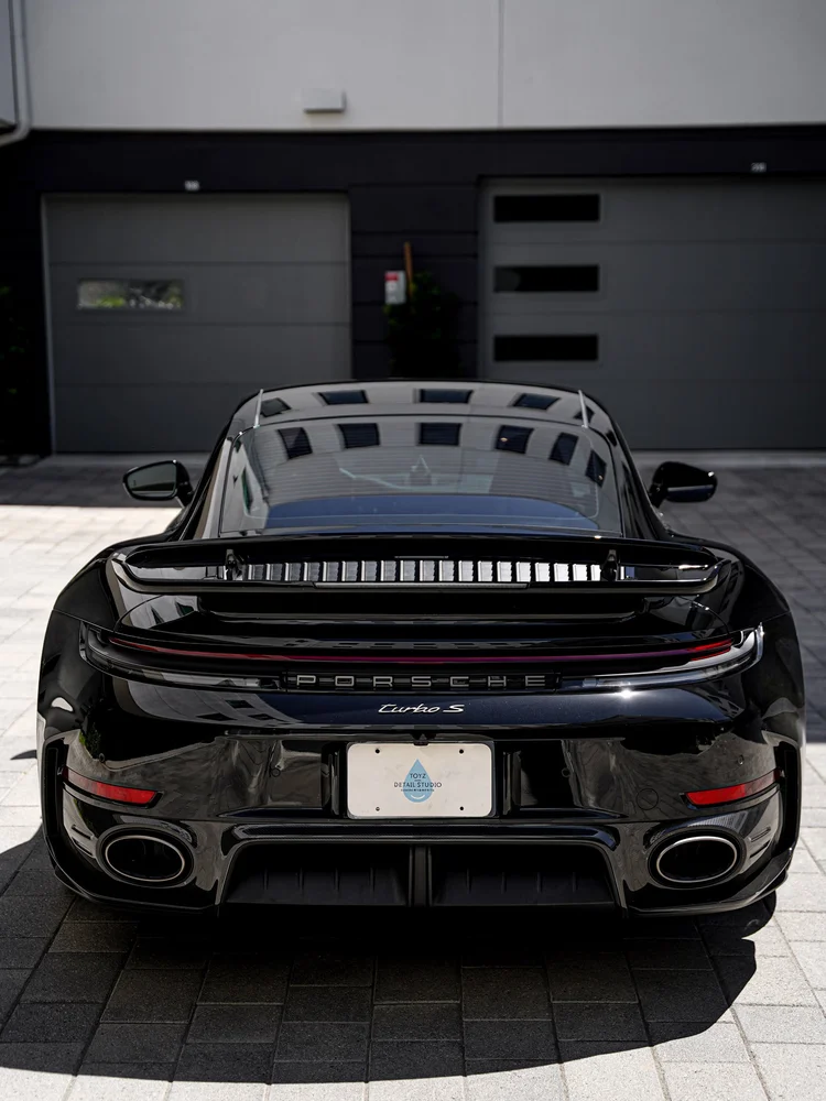 Straight-on rear view of the Turbo S with raised wing, light bar and oval exhaust outlets.