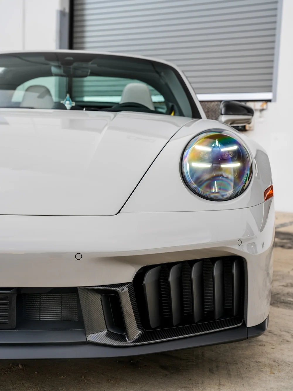 Porsche headlight and vertical lower intake bars in a close front view