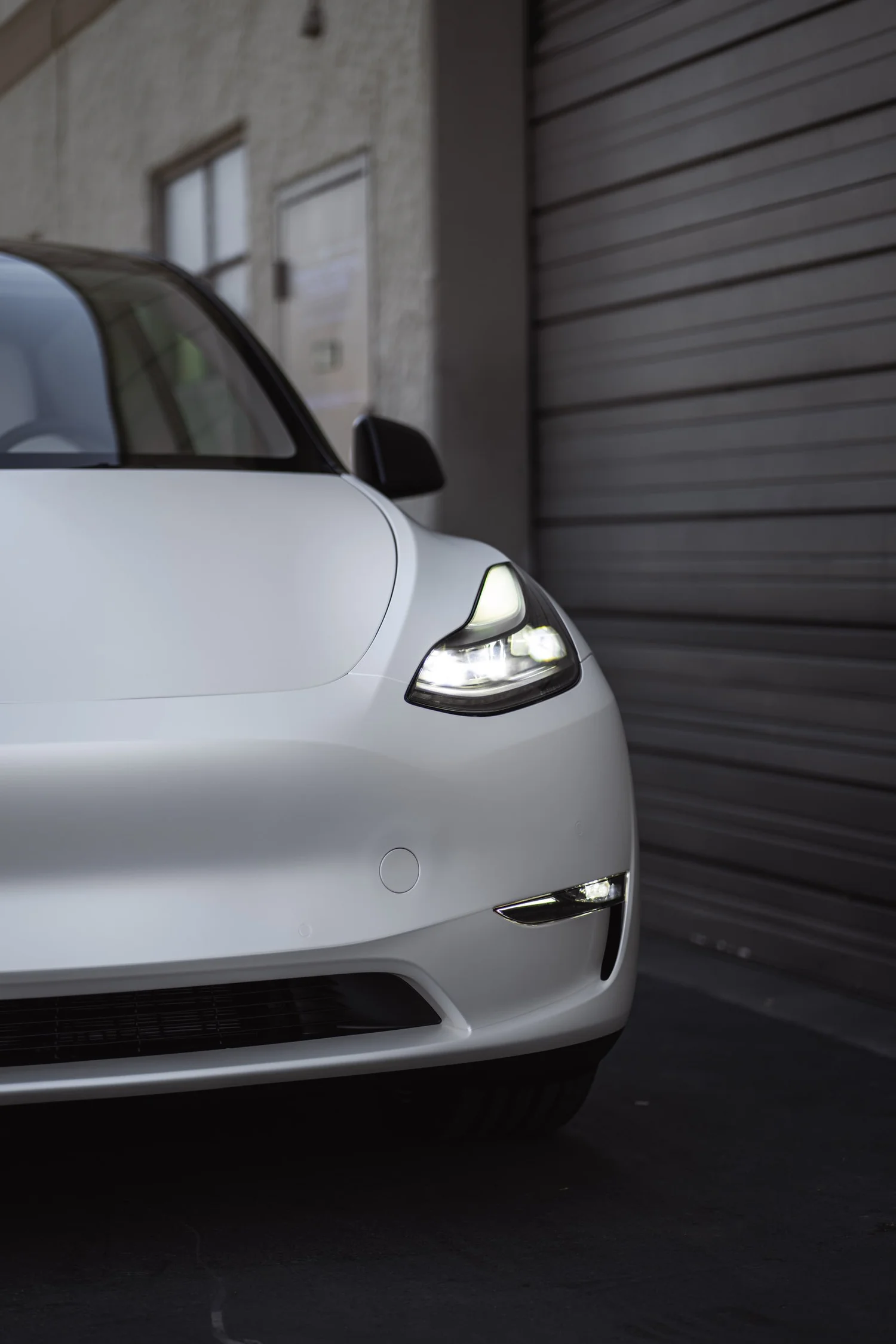 Satin Pearl White Tesla Model Y after Vinyl Wrap, low-angle front view
