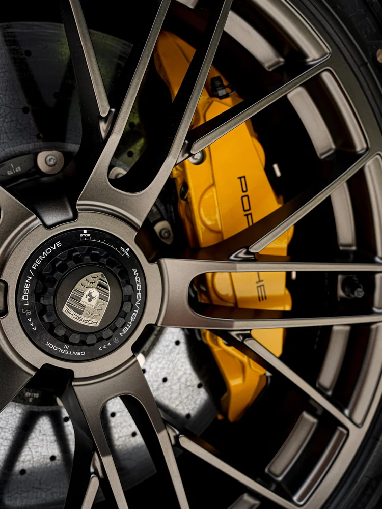 Close view of the Turbo S wheel spokes, center lock and yellow Porsche brake caliper.
