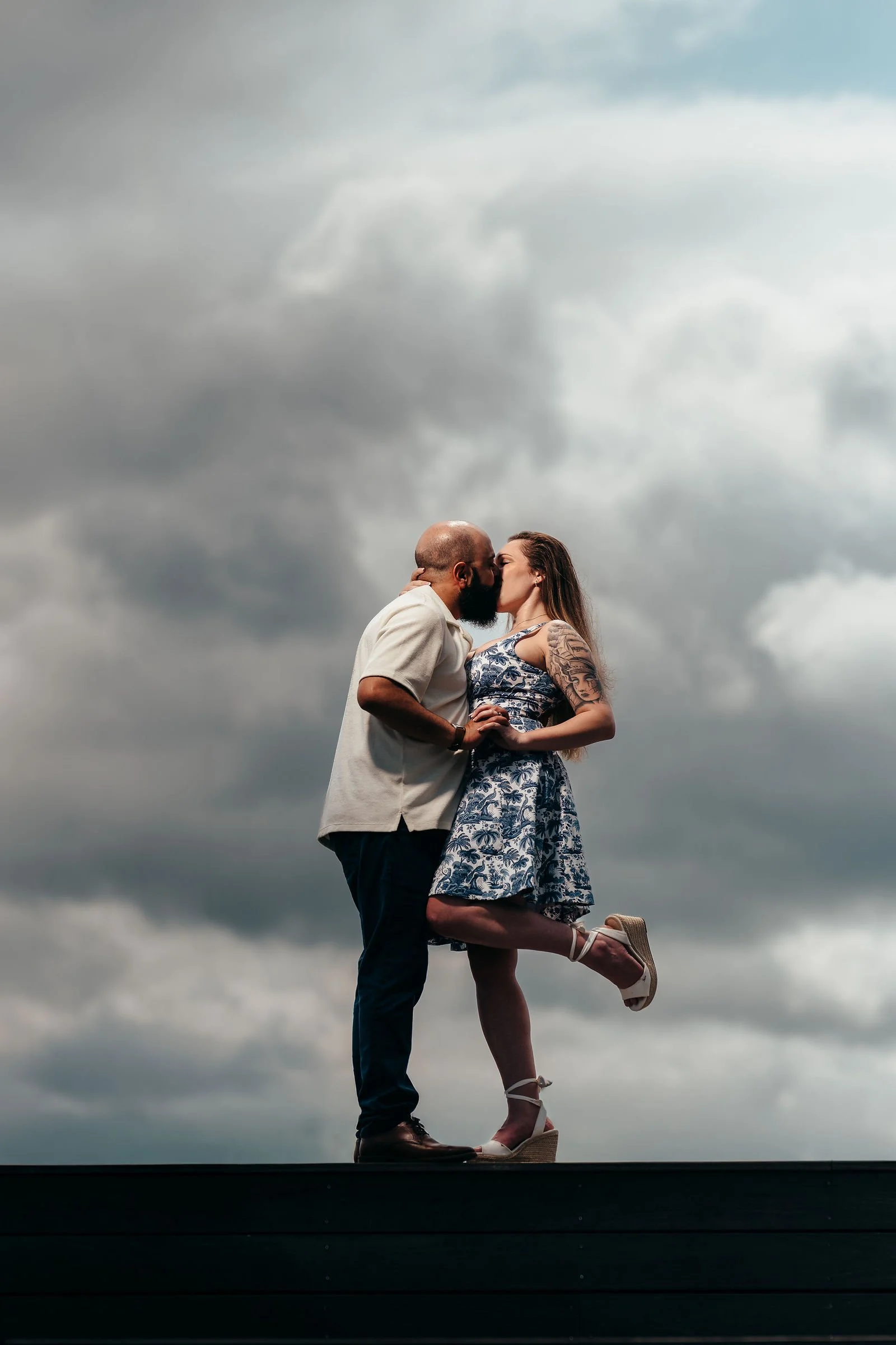 Moody dusk portrait of Aziz and Katherine on a Seaport pier, Boston engagement photographer
