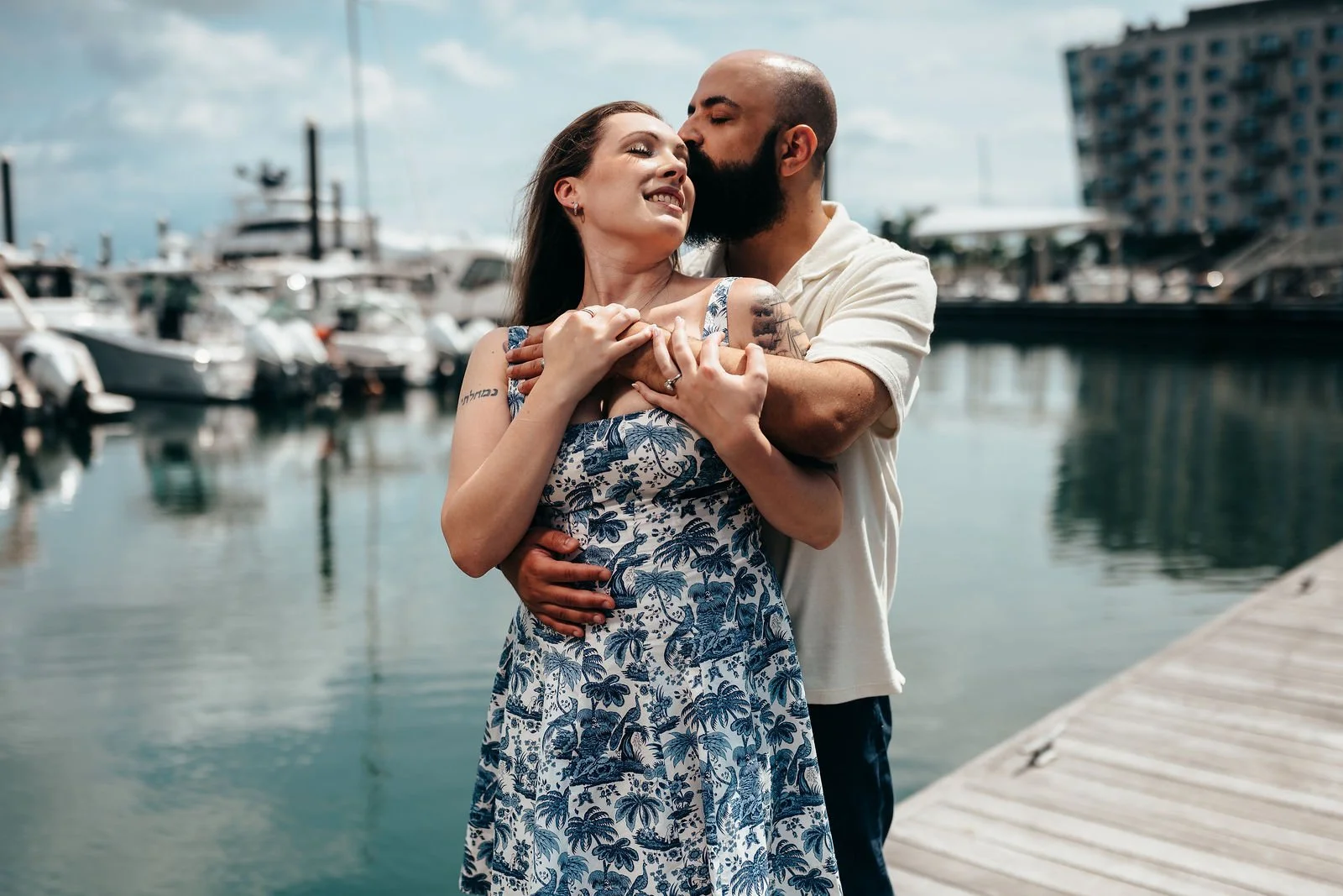 Aziz and Katherine embracing at the marina during their Boston engagement session