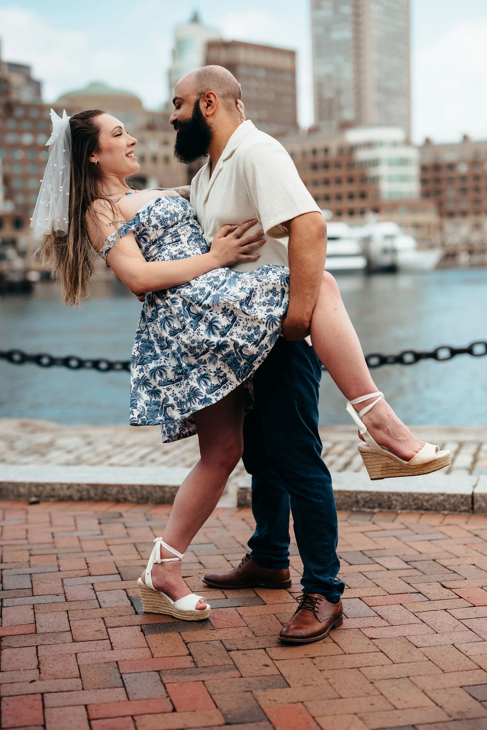 Aziz dipping Katherine by the water in Boston's Seaport
