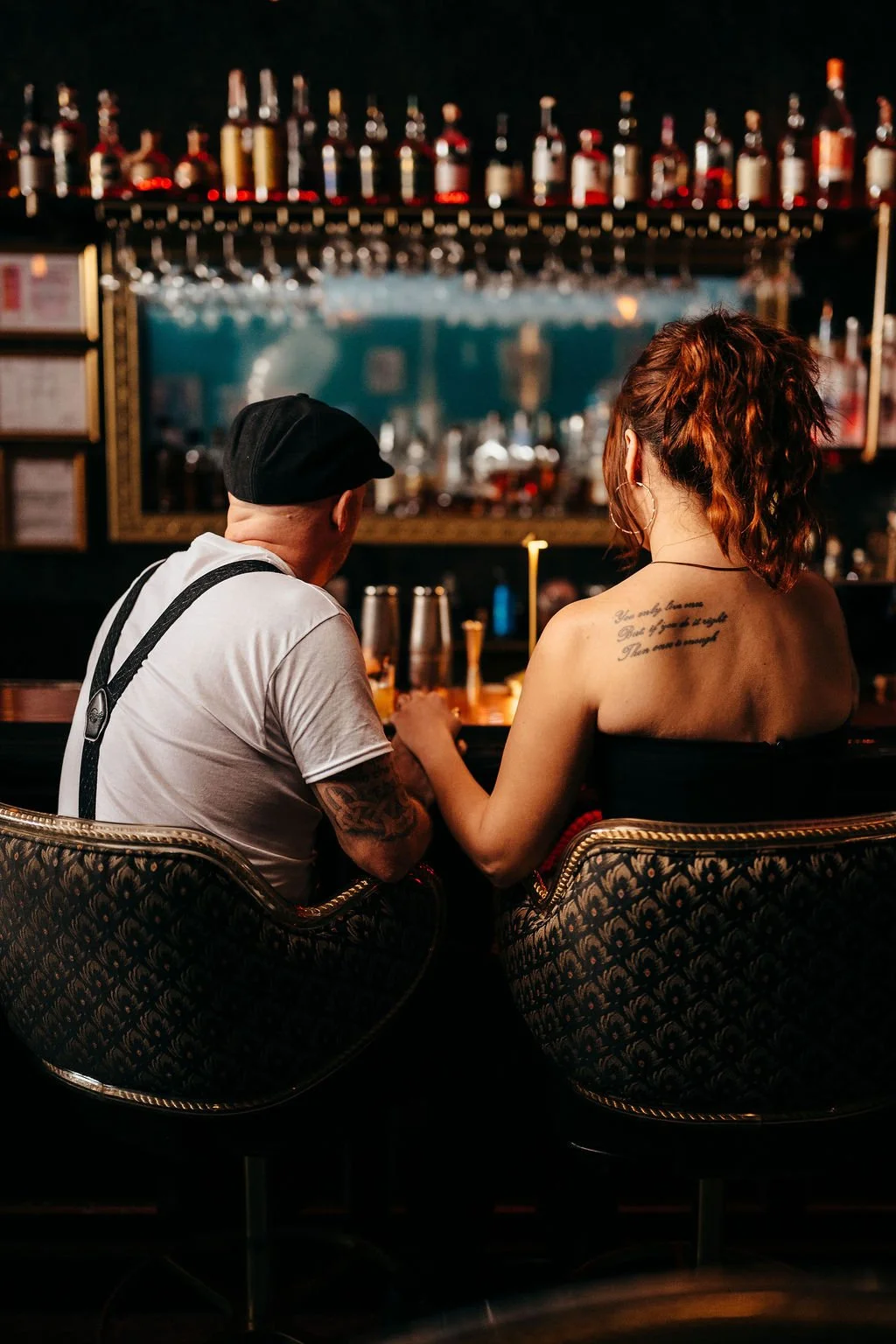 Kristin and Mike from behind at the bar during their speakeasy-style engagement session in Laconia NH