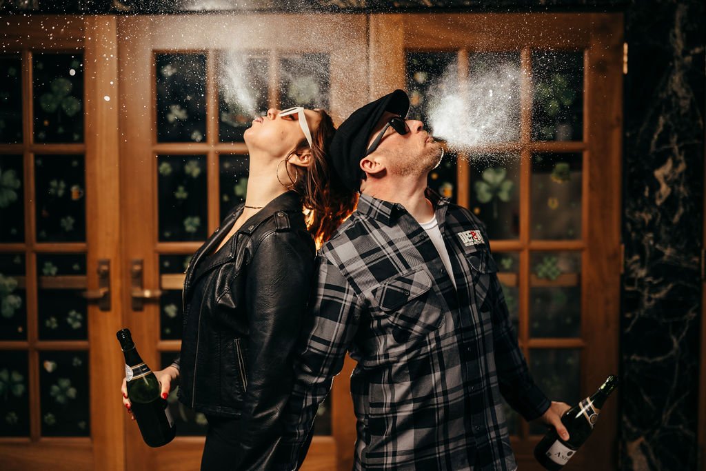 Kristin and Mike spraying champagne back-to-back, celebrating their engagement in Laconia NH