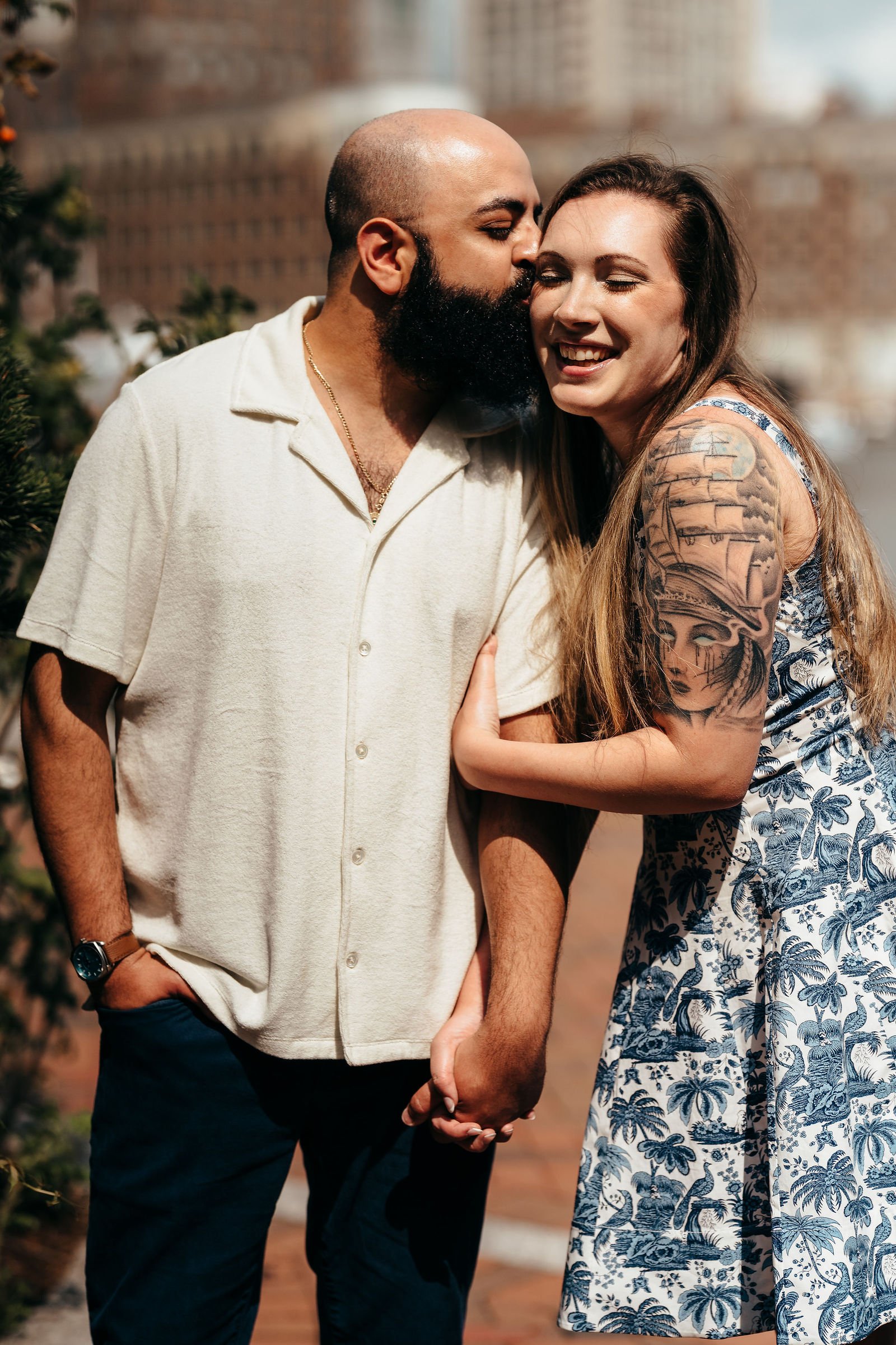 Aziz and Katherine laughing together, Seaport Boston engagement session