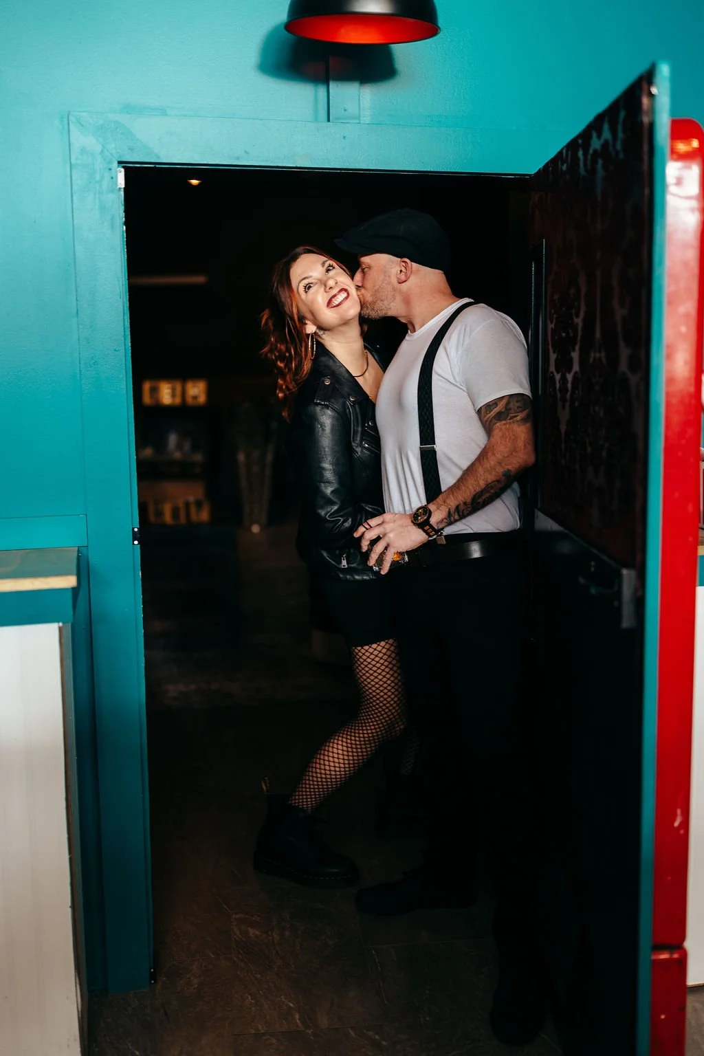 Kristin and Mike kissing in a teal doorway at The Candy Bar, Laconia NH