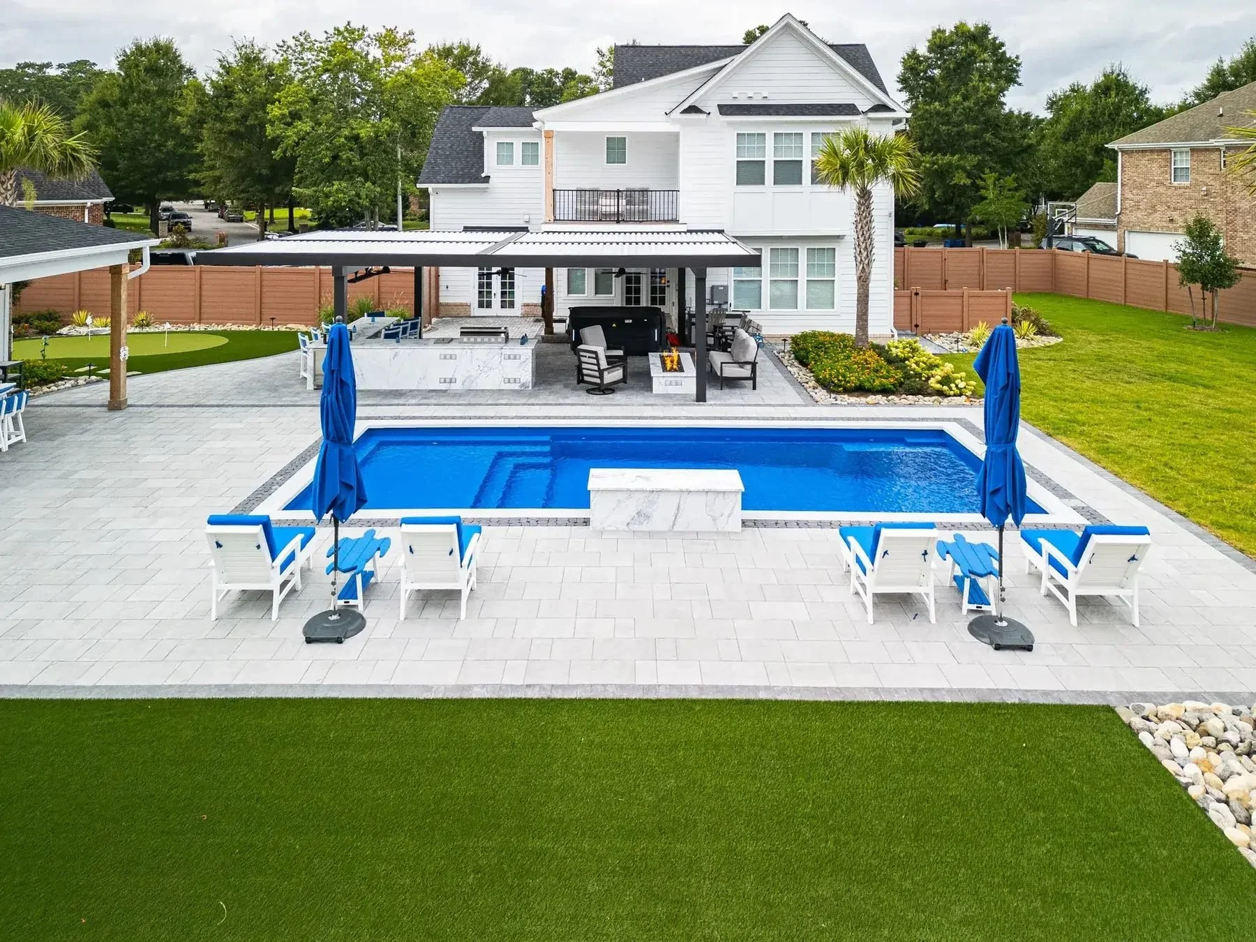Motorized louvered pergola over a poolside patio