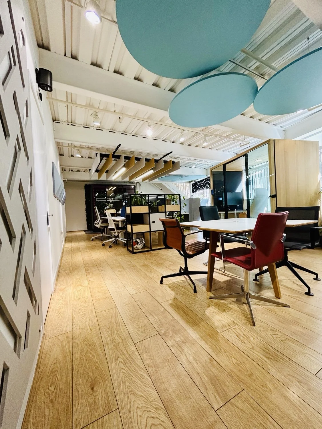 Basement work setting with acoustic ceiling treatments and enclosed office pod