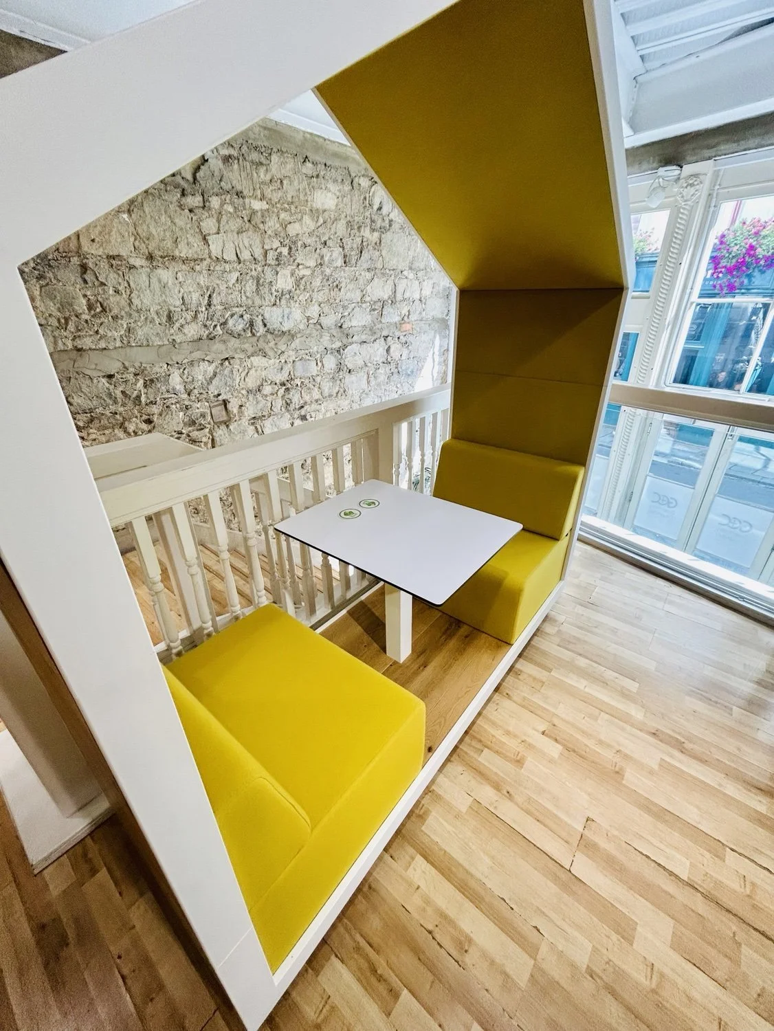 Yellow open meeting booth beside the first-floor windows at Chamber