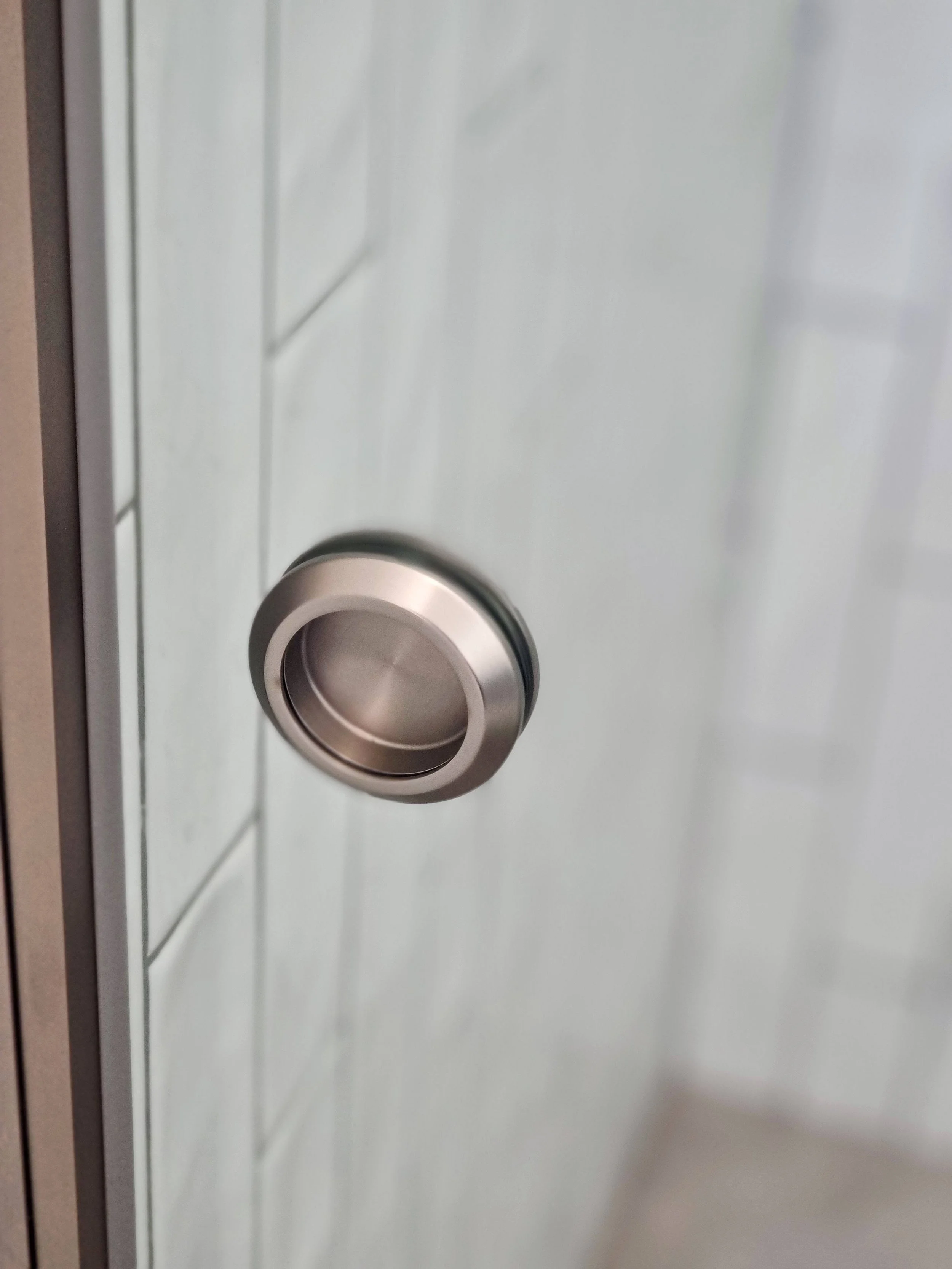 Brushed nickel recessed finger pull on sliding shower door