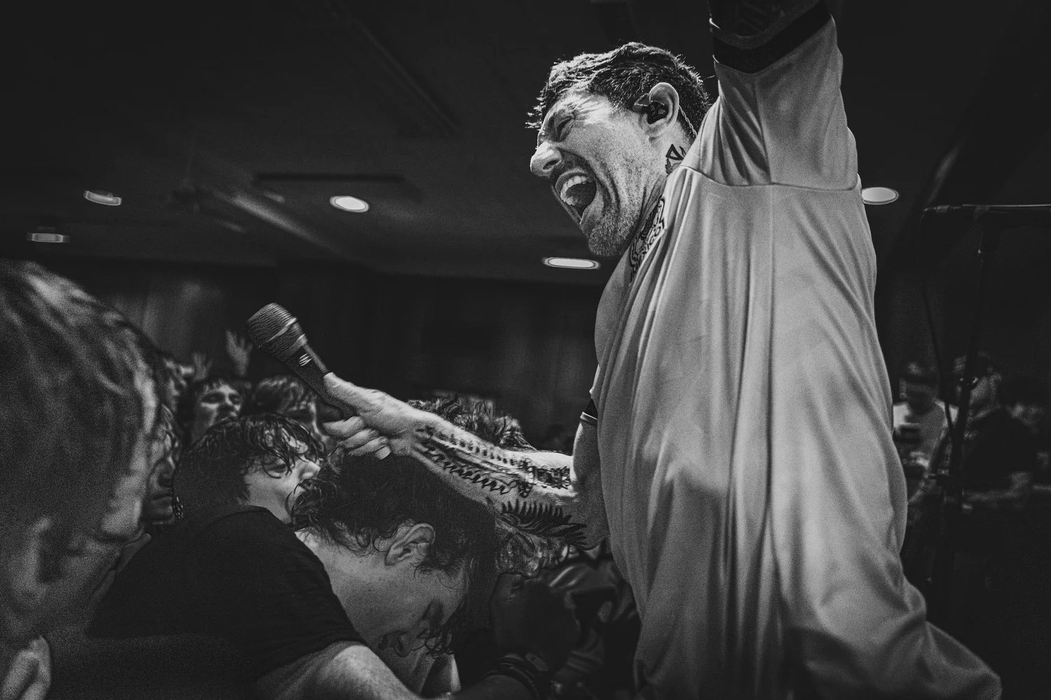 VANNA vocalist screaming into a microphone with one arm raised above the crowd in a black-and-white live shot