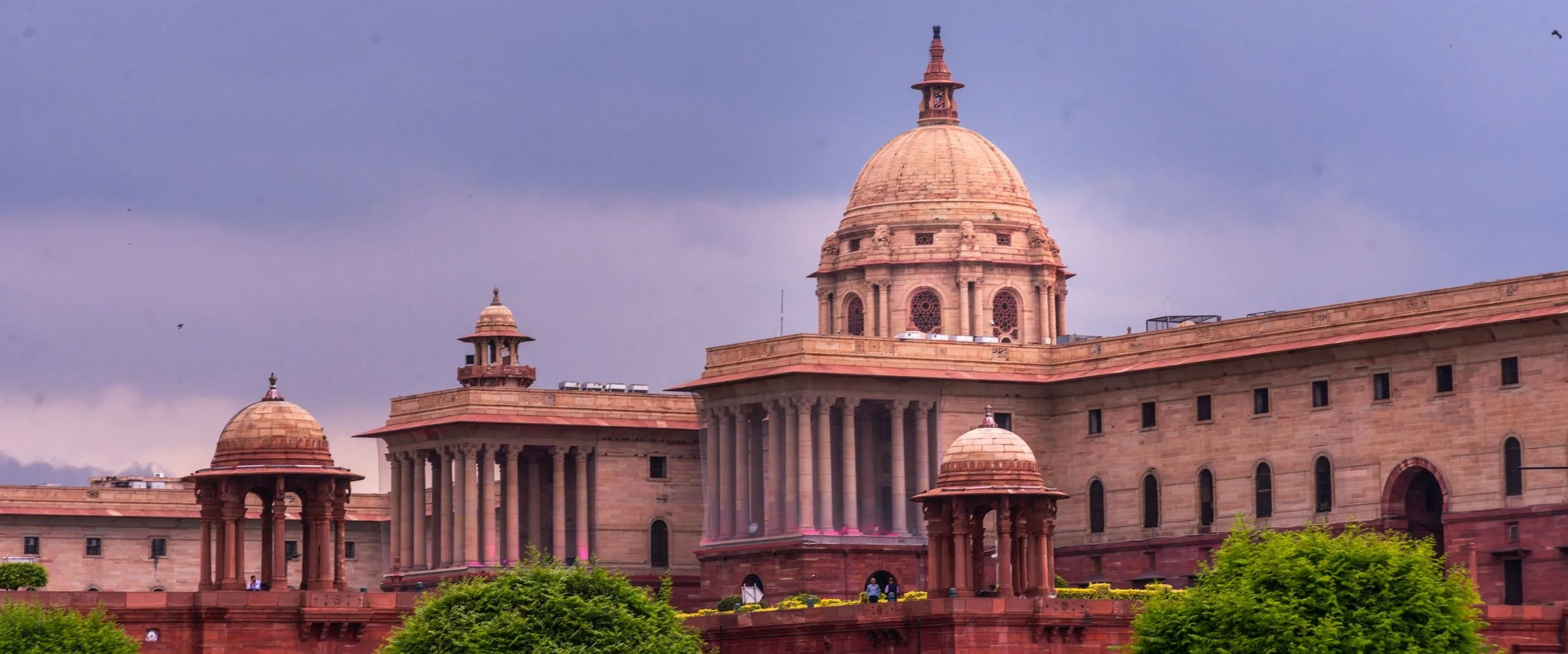 The domed government buildings on Raisina Hill, New Delhi, under a violet sky