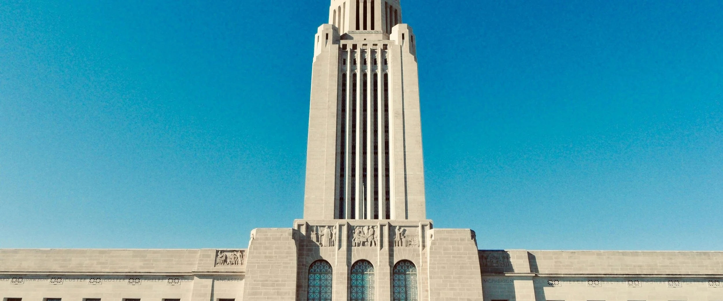 The tower of the Nebraska State Capitol against a clear blue sky