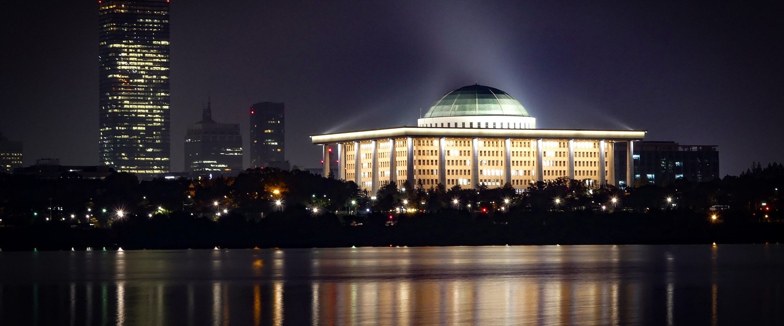 The National Assembly in Seoul lit at night across the Han River