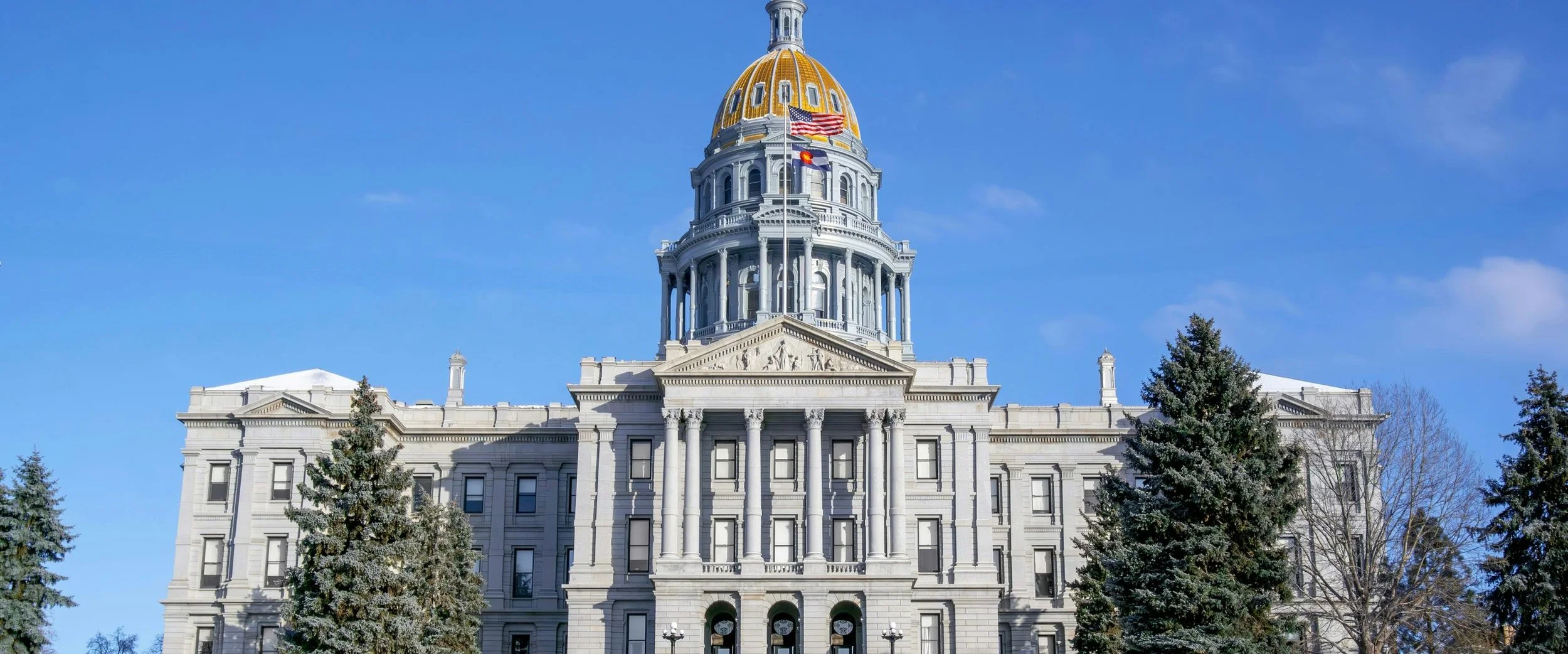 The gold dome of the Colorado State Capitol against a blue sky