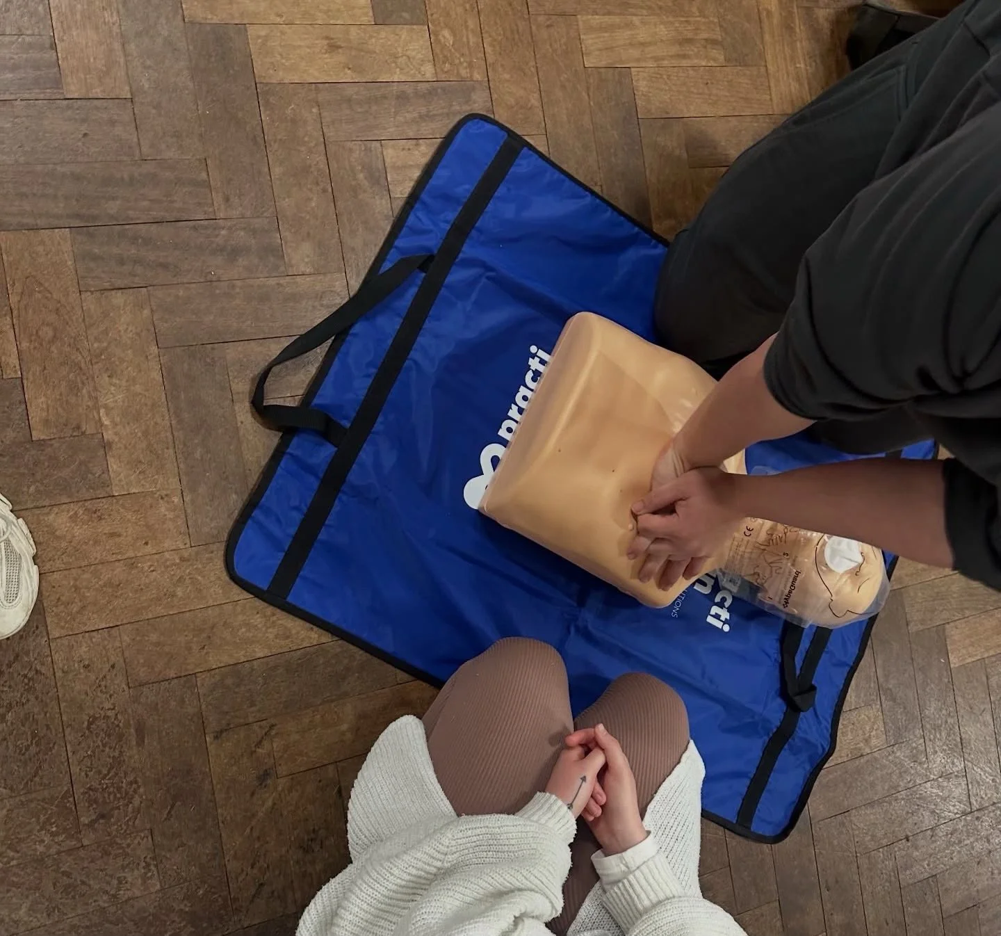 Instructor performs CPR on a mannequin during a training session