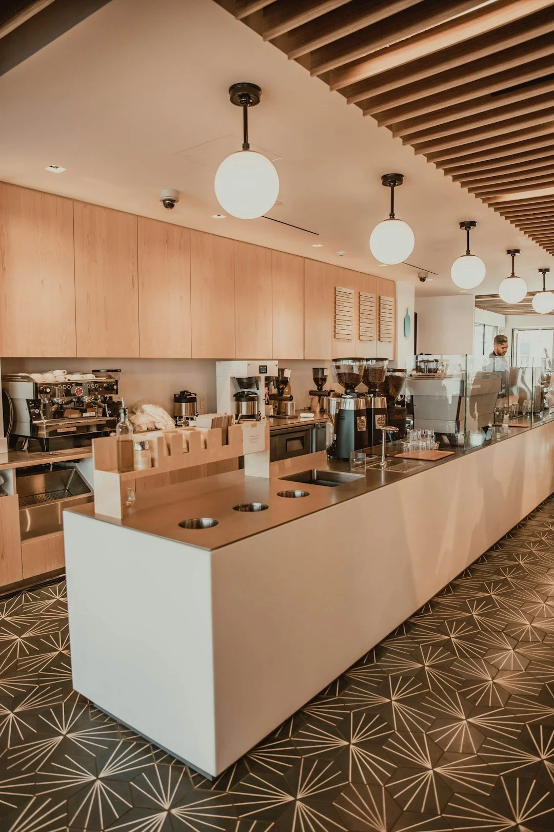 Modern commercial hospitality kitchen and service counter with stainless steel food-preparation equipment