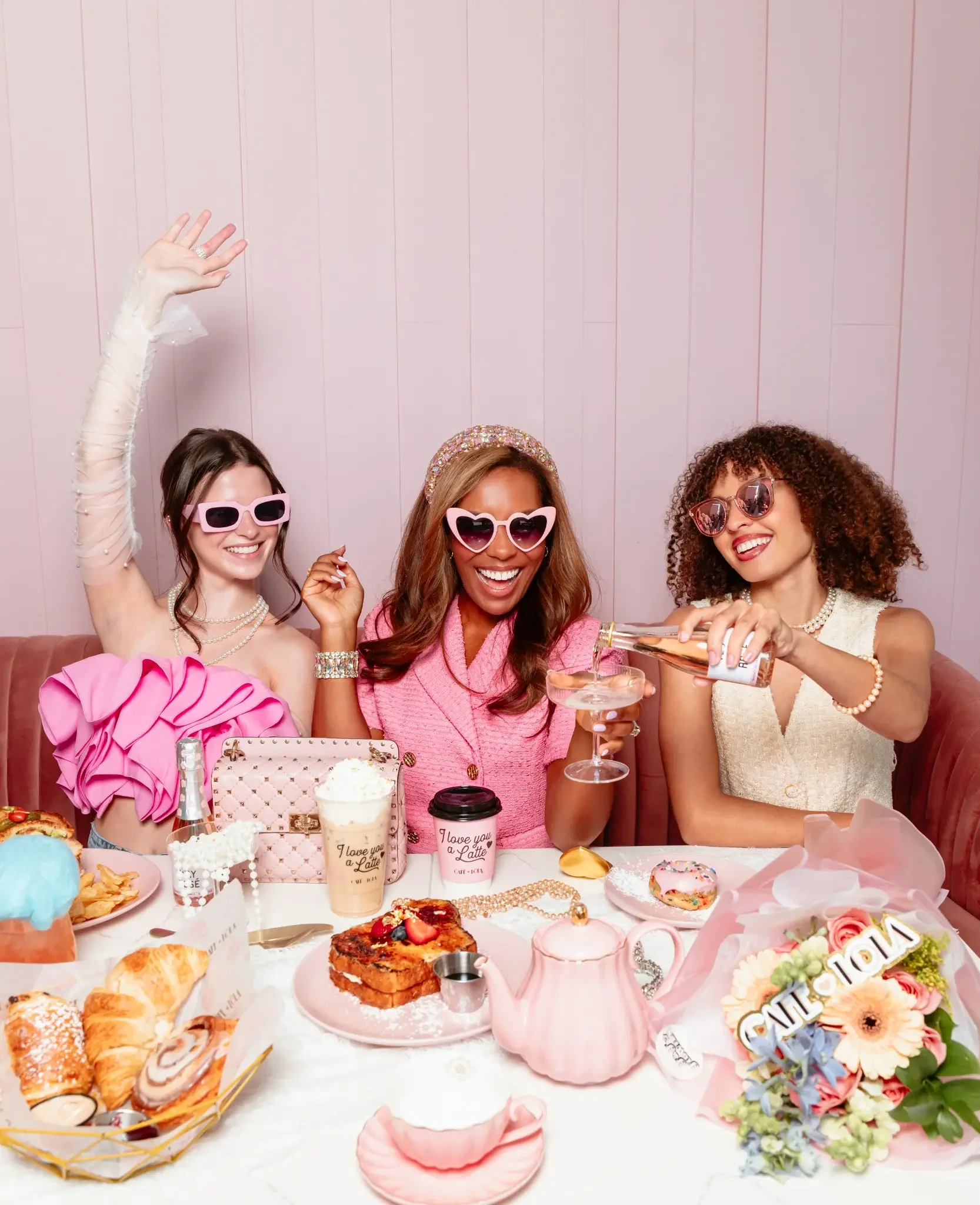 Lin Smith Jerome and two women celebrating around a full tea table at Café Lola
