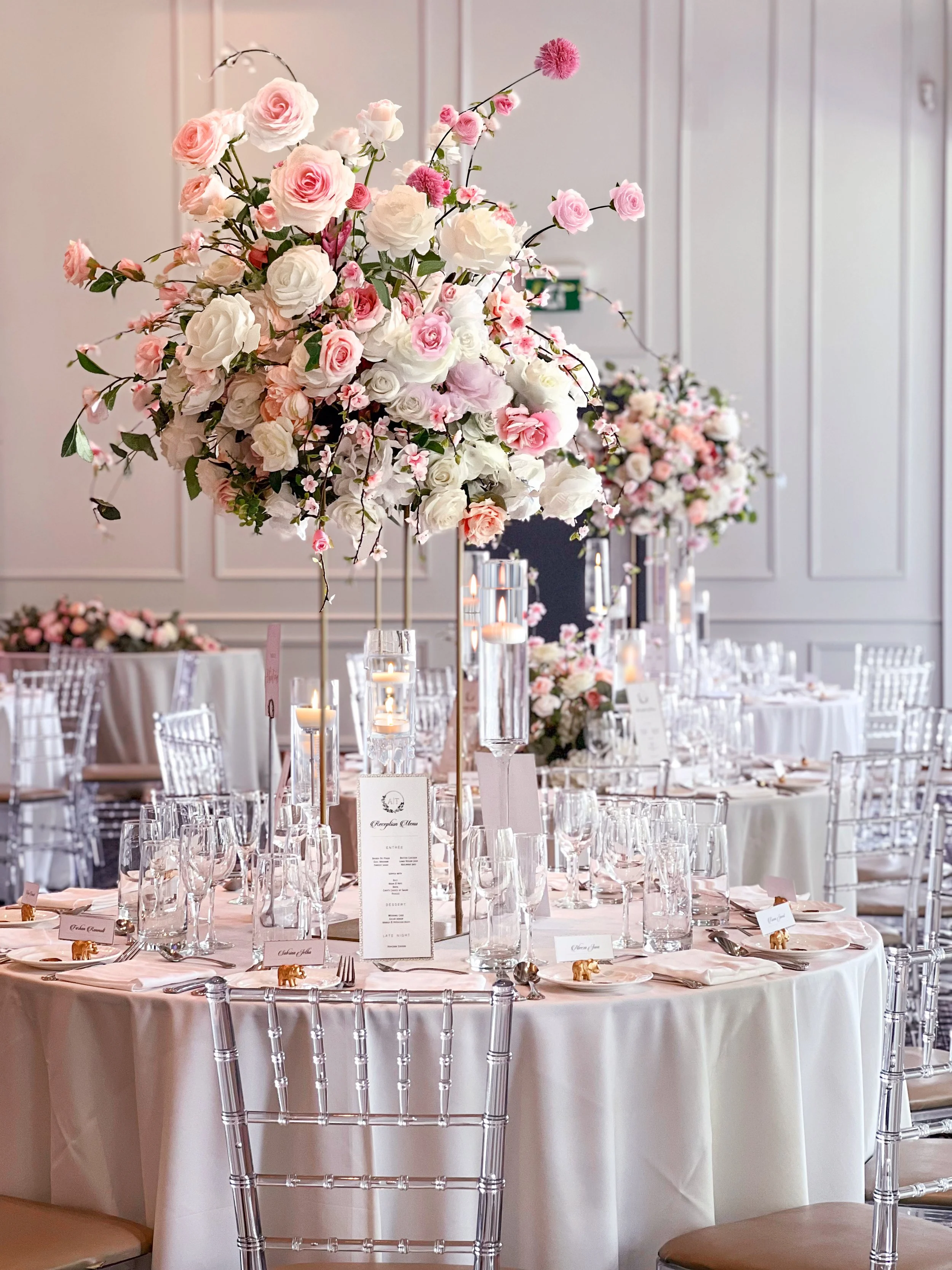 Romantic wedding table decor with elevated pink and white florals, floating candles and elegant reception styling at The Guild Inn.