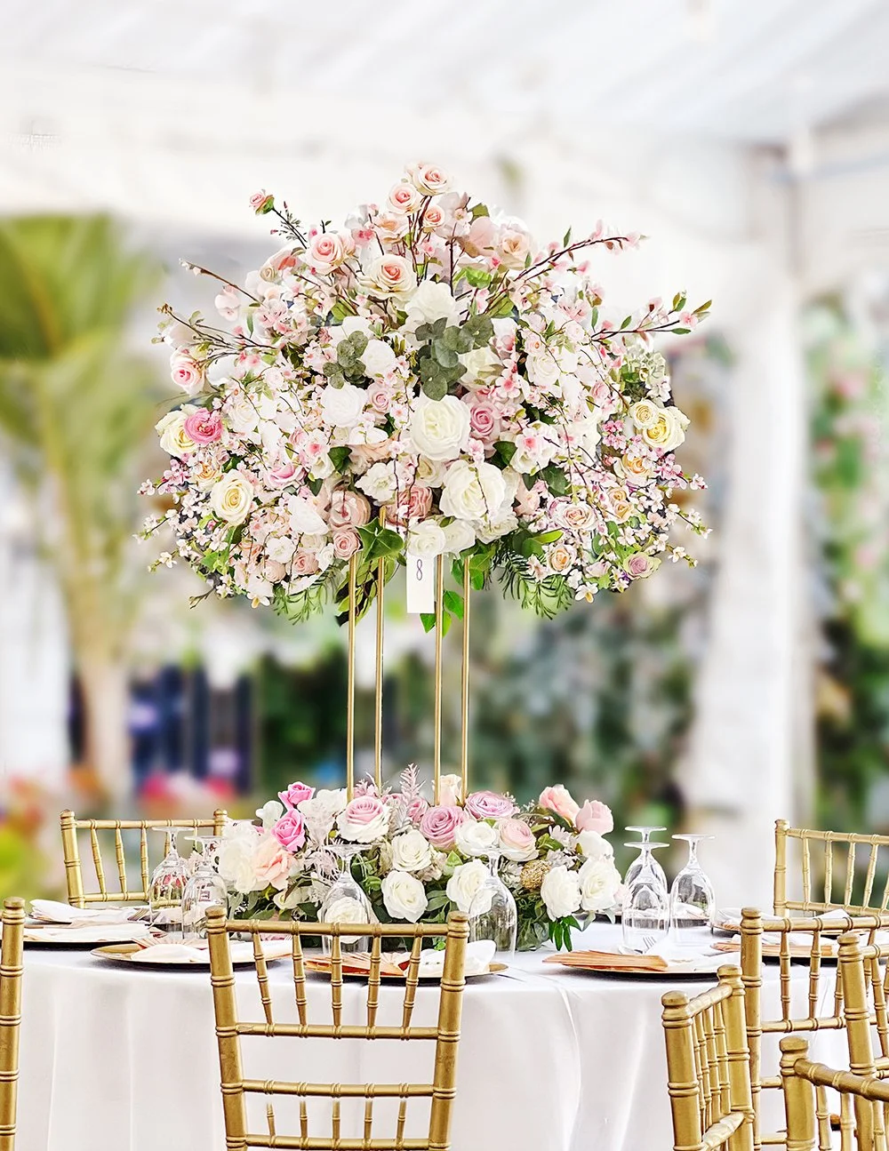 Luxury engagement centerpiece featuring blush pink and ivory roses, delicate blossoms, greenery and a tall gold floral stand.