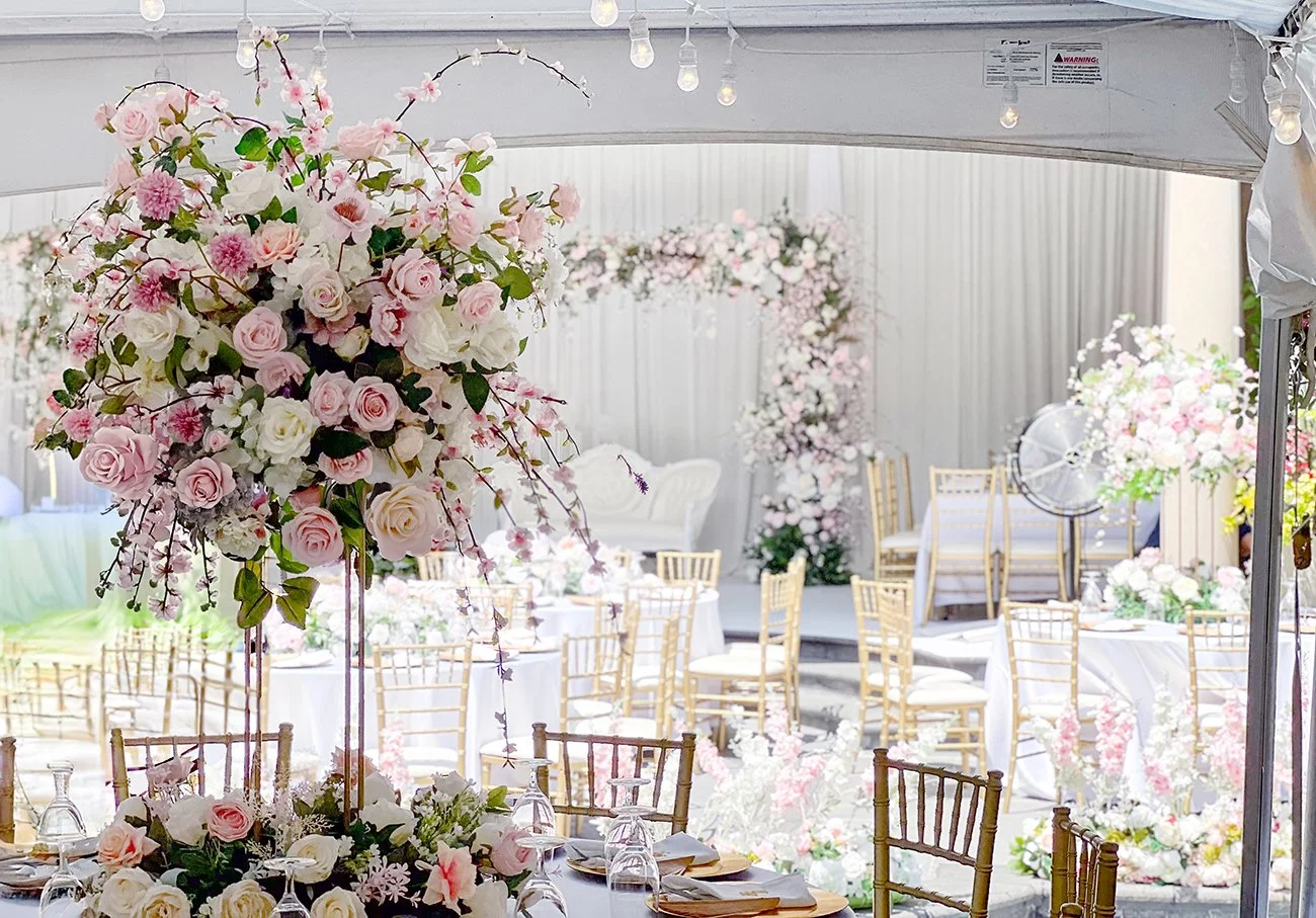 Luxury engagement centerpiece featuring blush pink and ivory roses, delicate blossoms, greenery and a tall gold floral stand.