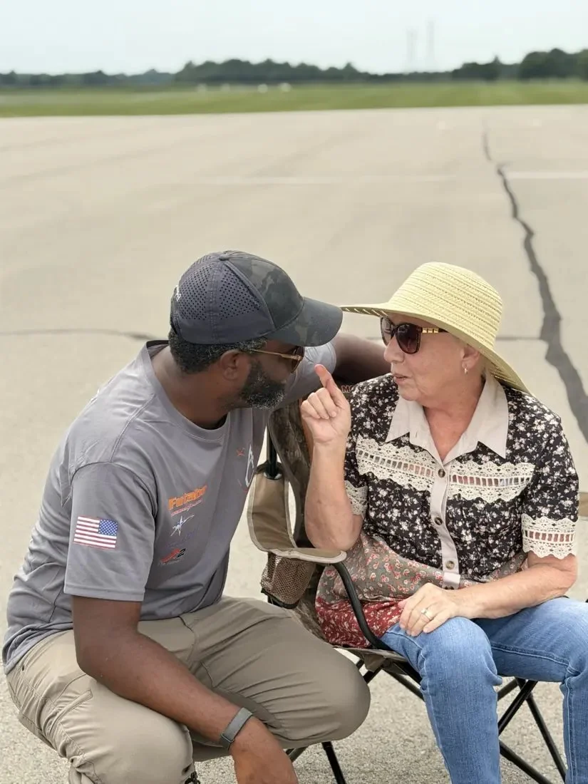 Linda Jesky, in her sun hat, talking with AC Glenn on the flightline.