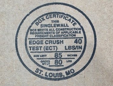 Close-up of a box maker's certificate stamp showing the edge crush test rating