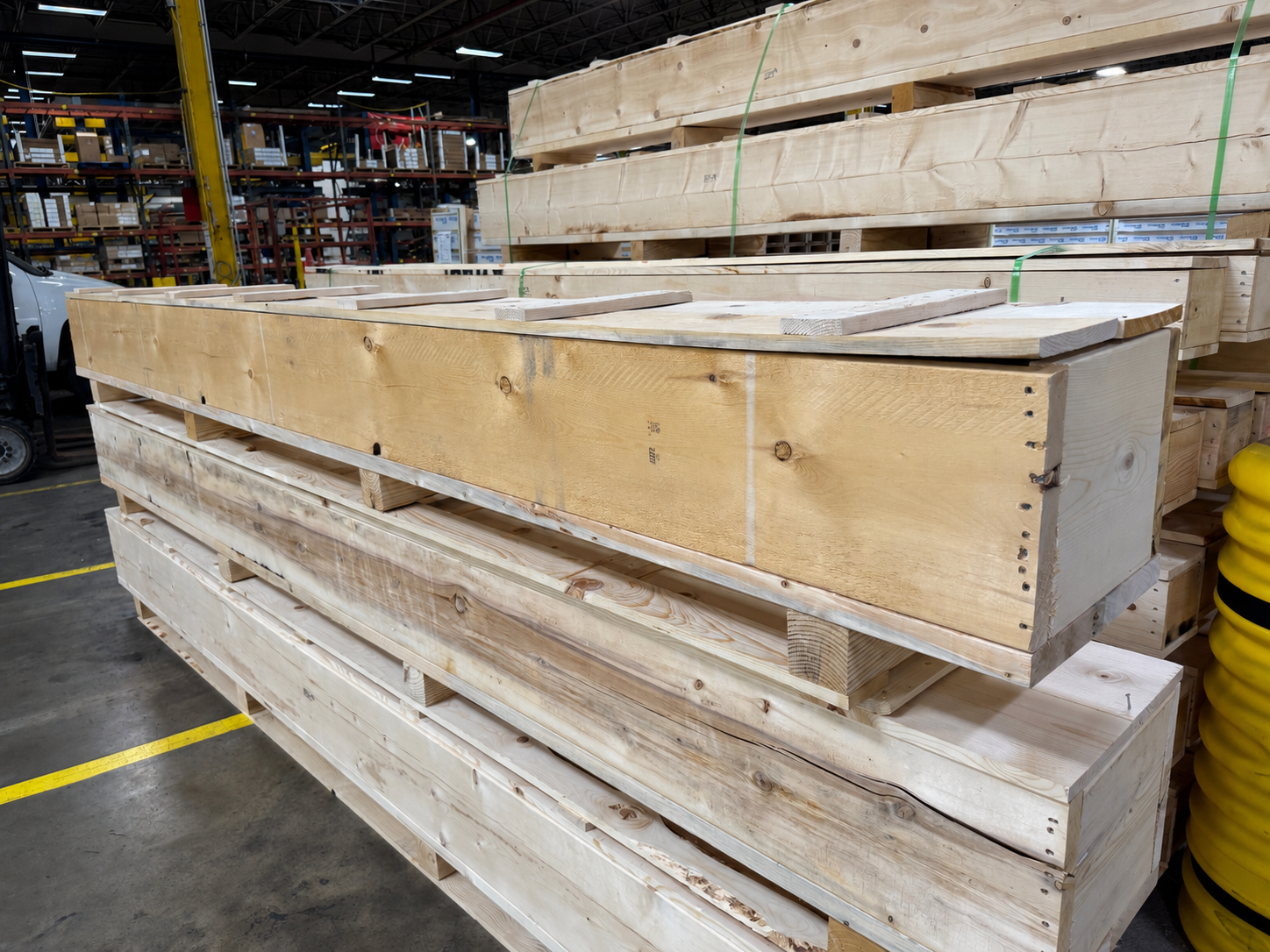 Long heat-treated export crates stacked and strapped at a warehouse, built for steel product