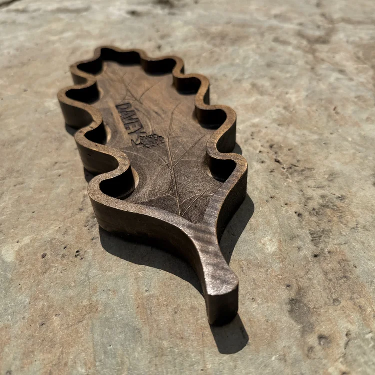 Custom carved oak-leaf tray with a company logo and detailed wood-grain finish