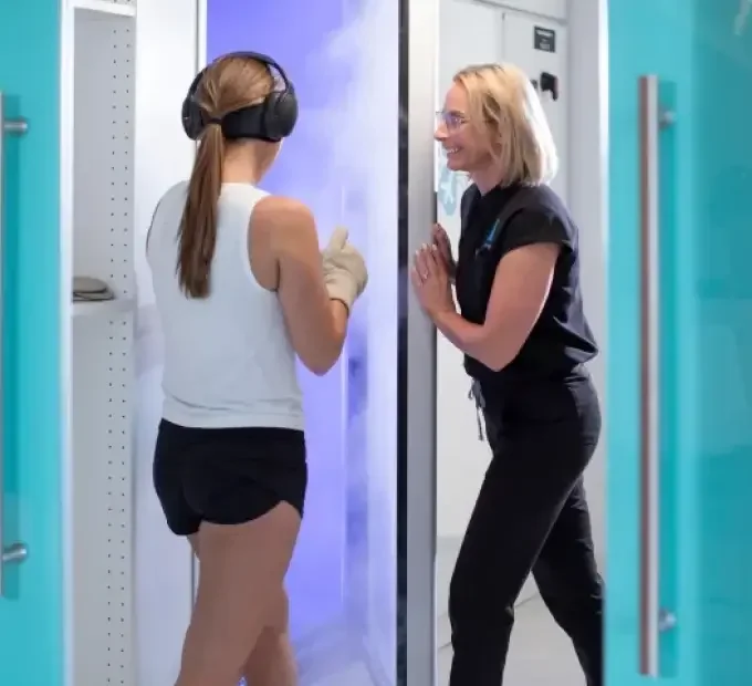 Client and technician using a whole body cryotherapy chamber at Huemn Houston