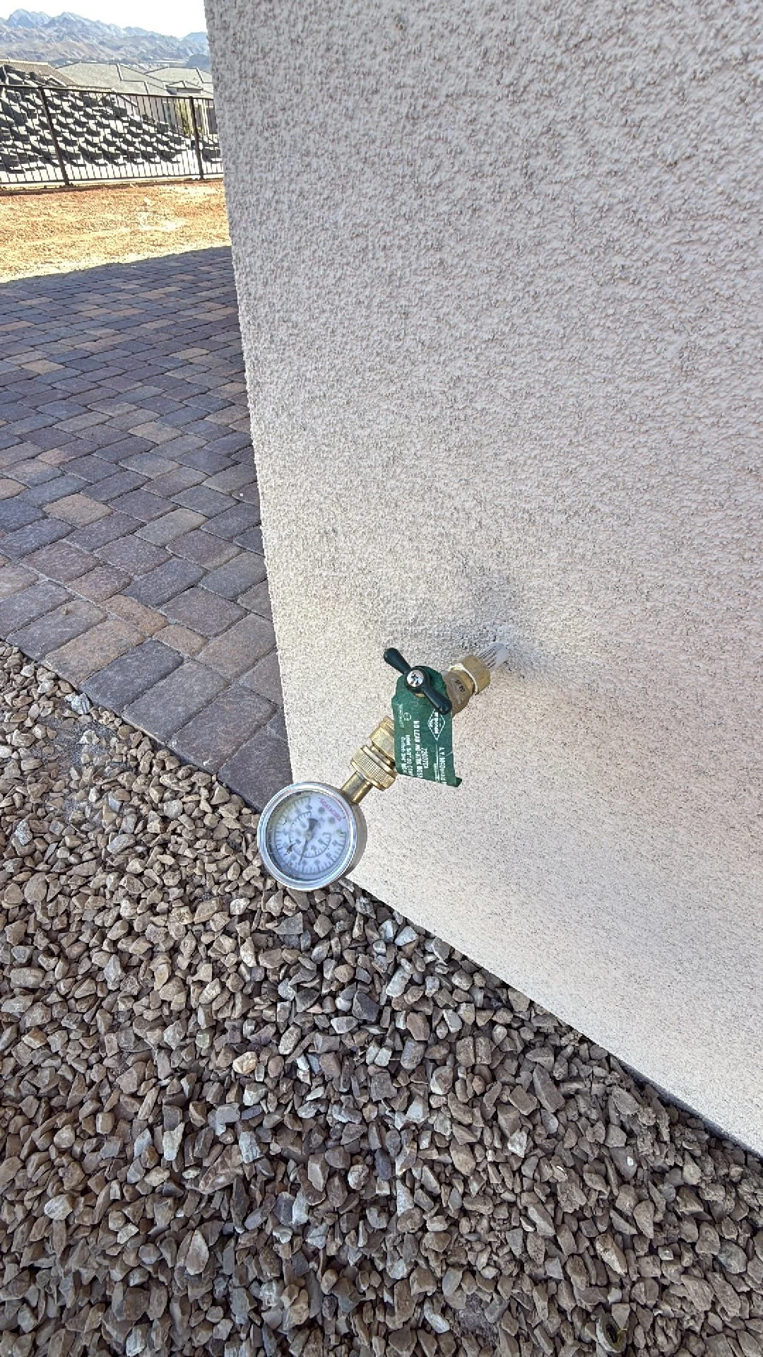 Water pressure gauge attached to an outdoor hose bib showing high pressure