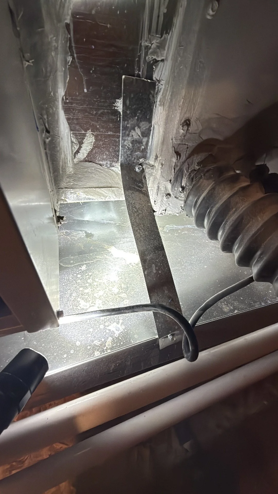 Water stains inside the secondary catch pan under an HVAC unit