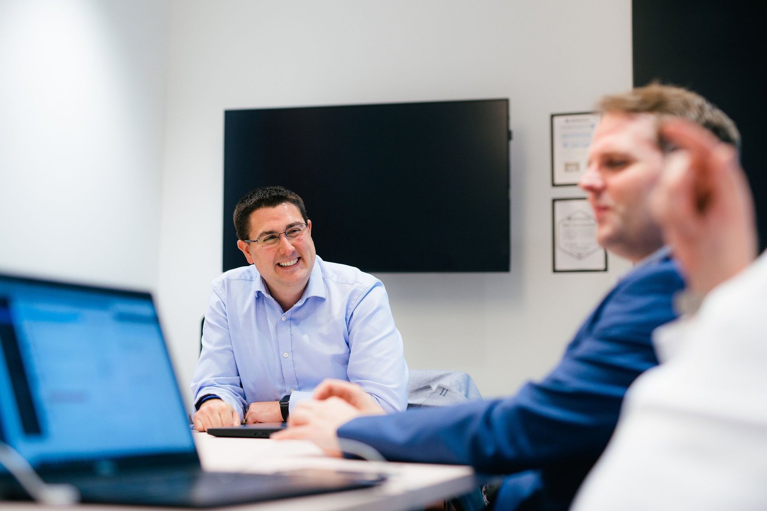 Karl Nicholson in conversation with colleagues around a meeting table